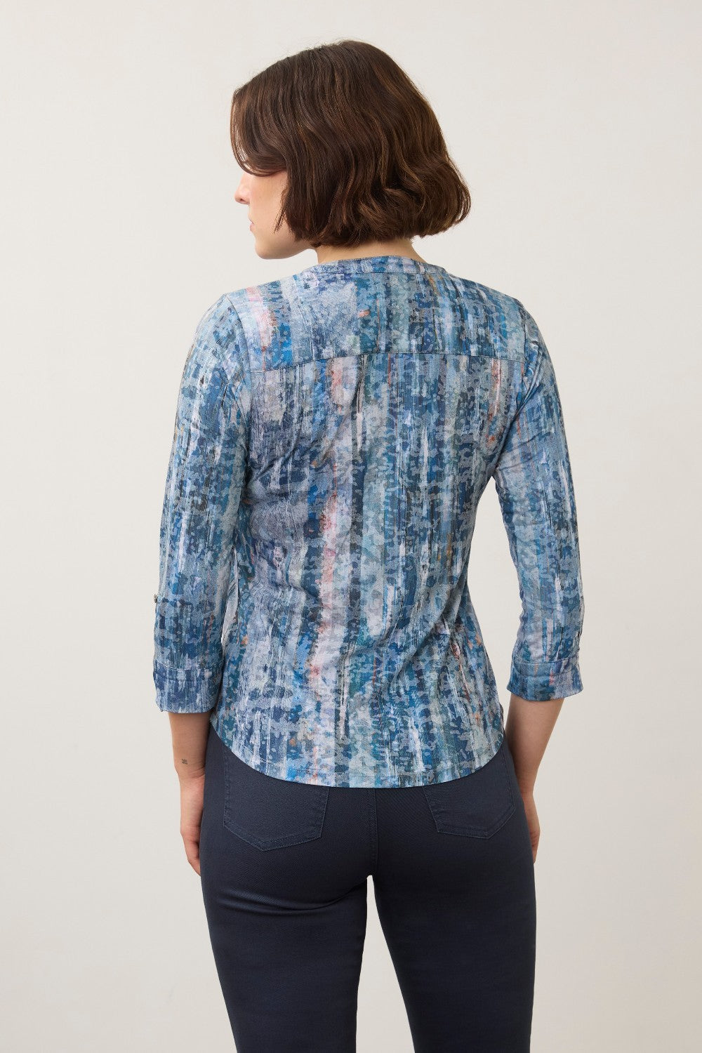 Back view of a woman wearing a Broderick's Clothing Co. FDJ indigo patterned 3/4 sleeve henley top with dark jeans.