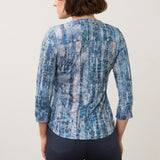 Back view of a woman wearing a Broderick's Clothing Co. FDJ indigo patterned 3/4 sleeve henley top with dark jeans.