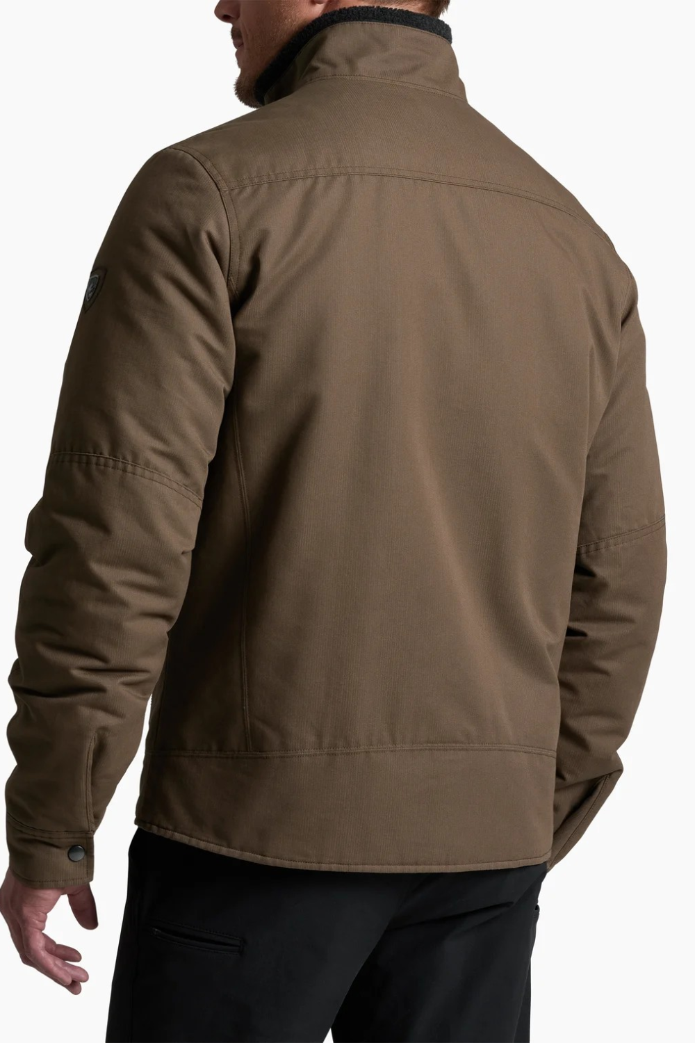 Back view of a man wearing a brown KÜHL BURR Insulated Jacket from Broderick's Clothing Co. with a berber collar.