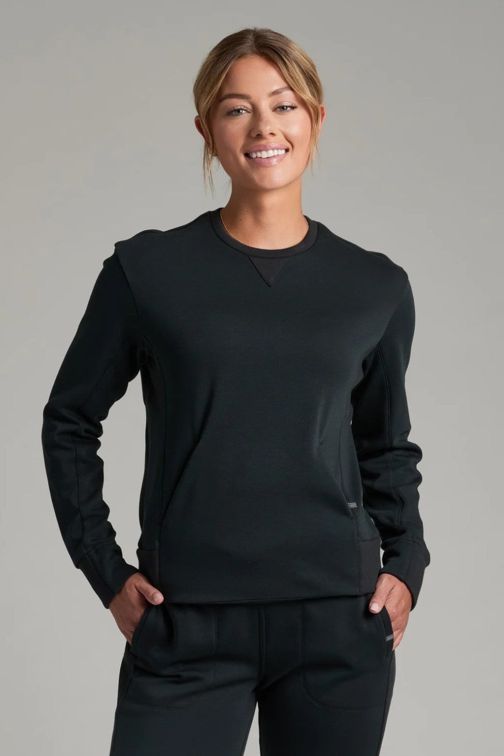 Broderick's Clothing Co. KÜHL Kozy black crewneck sweatshirt with rib paneling and kangaroo pocket on a female model