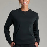 Broderick's Clothing Co. KÜHL Kozy black crewneck sweatshirt with rib paneling and kangaroo pocket on a female model