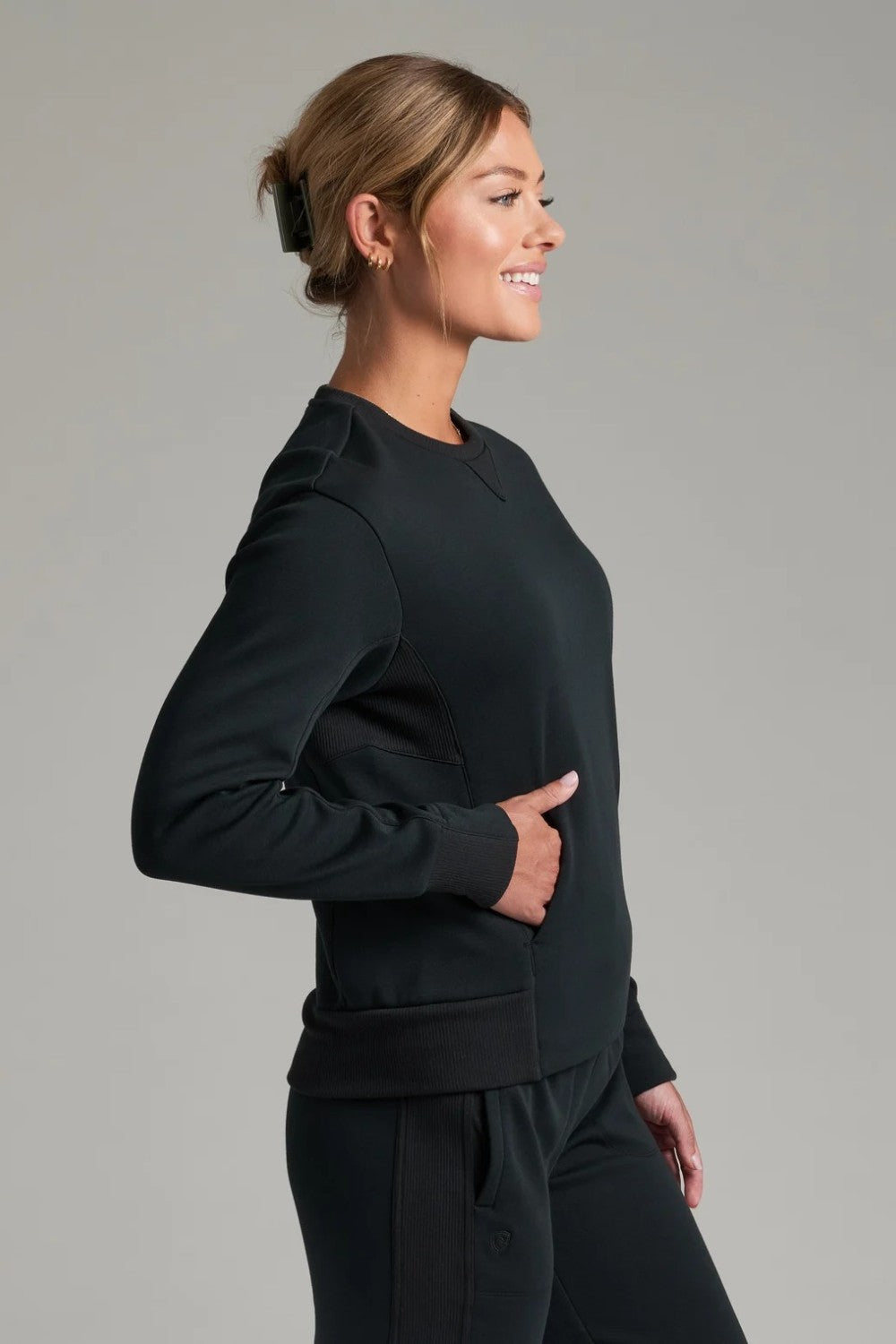 Broderick's Clothing Co. KÜHL Kozy black crewneck sweatshirt with rib paneling and side pockets on a female model