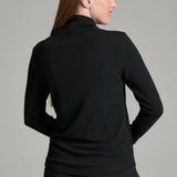 Woman wearing a black KÜHL Remi Pullover with a turtleneck and crinkle-rib texture from Broderick's Clothing Co.