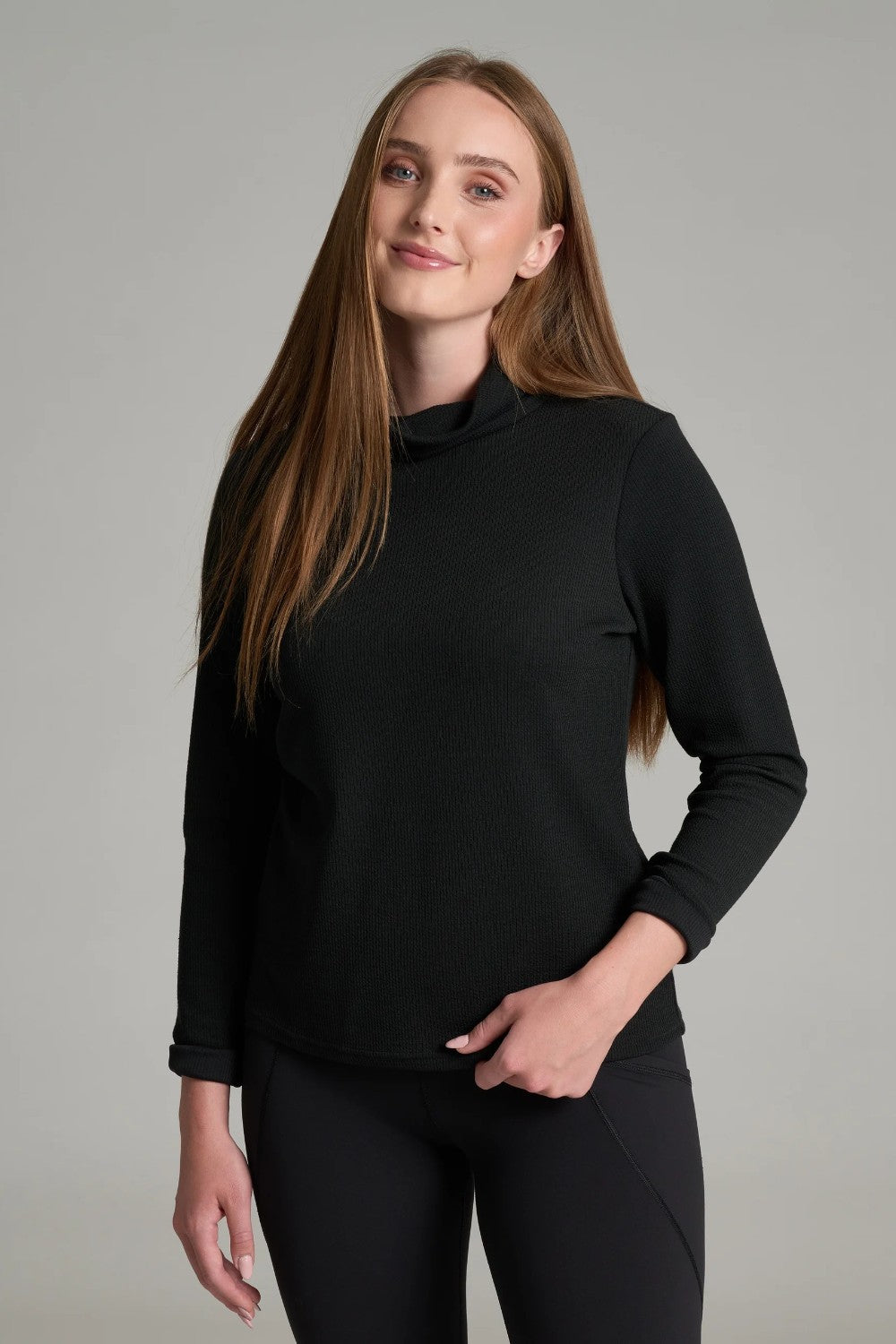 Broderick's Clothing Co. KÜHL Remi black turtleneck pullover with crinkle rib texture worn by a smiling woman