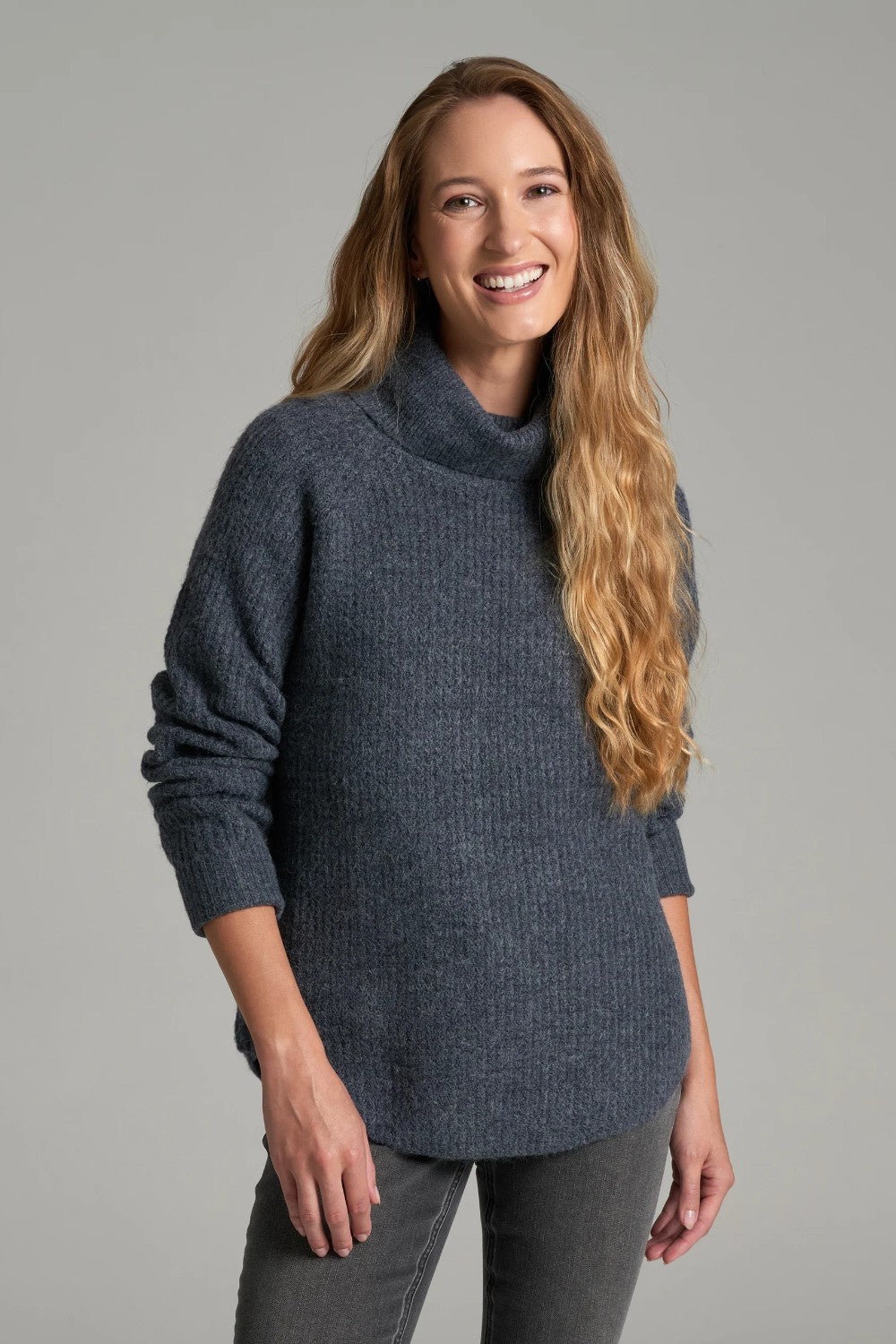 Broderick's Clothing Co. KÜHL Sienna charcoal grey chunky knit sweater with a ribbed cowl neck on a smiling woman