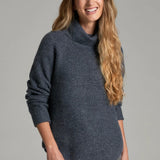 Broderick's Clothing Co. KÜHL Sienna charcoal grey chunky knit sweater with a ribbed cowl neck on a smiling woman