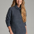Broderick's Clothing Co. KÜHL Sienna charcoal grey chunky knit sweater with a ribbed cowl neck on a smiling woman