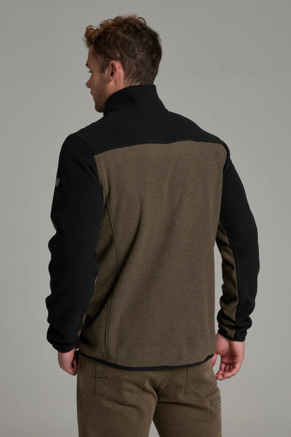 Broderick's Clothing Co. KÜHL SKORCHR fleece quarter-zip sweater in olive and black, worn by a man, back view.