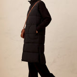 Broderick's Clothing Co. long black quilted vest with zip-front, worn by a model over a matching black outfit.