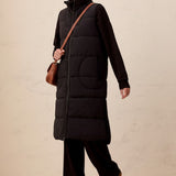 Broderick's Clothing Co. long black quilted vest with zip-front closure worn by a smiling woman in a studio setting.