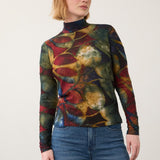 Broderick's Clothing Co. long sleeve mock neck top with a bold multi-colored leaf print worn with blue jeans.