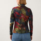 Broderick's Clothing Co. long sleeve mock neck top with a bold multicolored abstract print worn with blue jeans.
