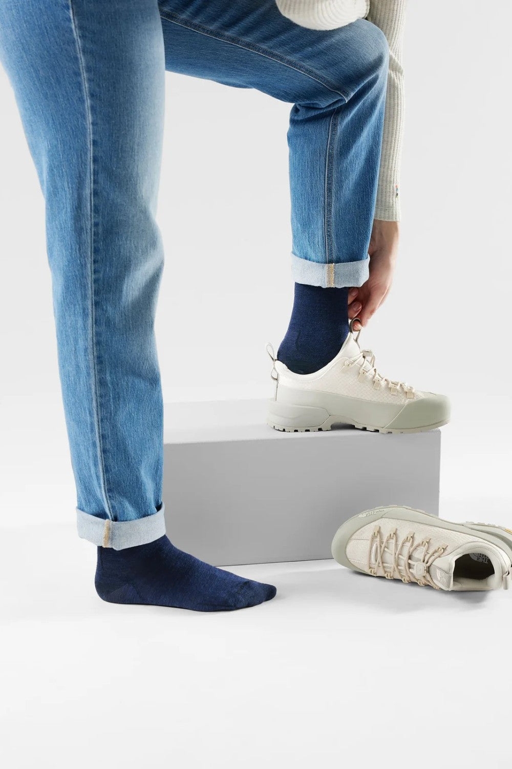 Broderick's Clothing Co. navy blue Merino wool crew socks worn with cuffed jeans and light beige sneakers