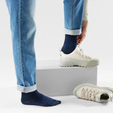 Broderick's Clothing Co. navy blue Merino wool crew socks worn with cuffed jeans and light beige sneakers