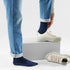 Broderick's Clothing Co. navy blue Merino wool crew socks worn with cuffed jeans and light beige sneakers