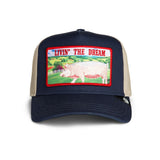 Broderick's Clothing Co. navy trucker hat with a Livin' The Dream pig patch and beige mesh back