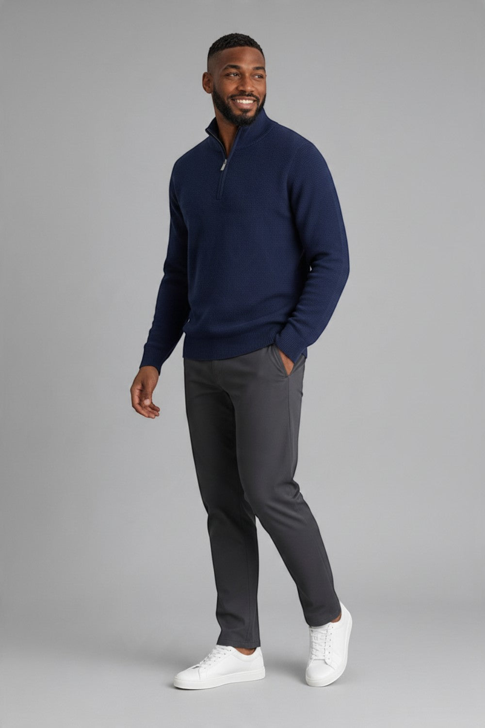Broderick's Clothing Co. navy blue textured cotton quarter-zip sweater worn by a man with grey trousers and sneakers.