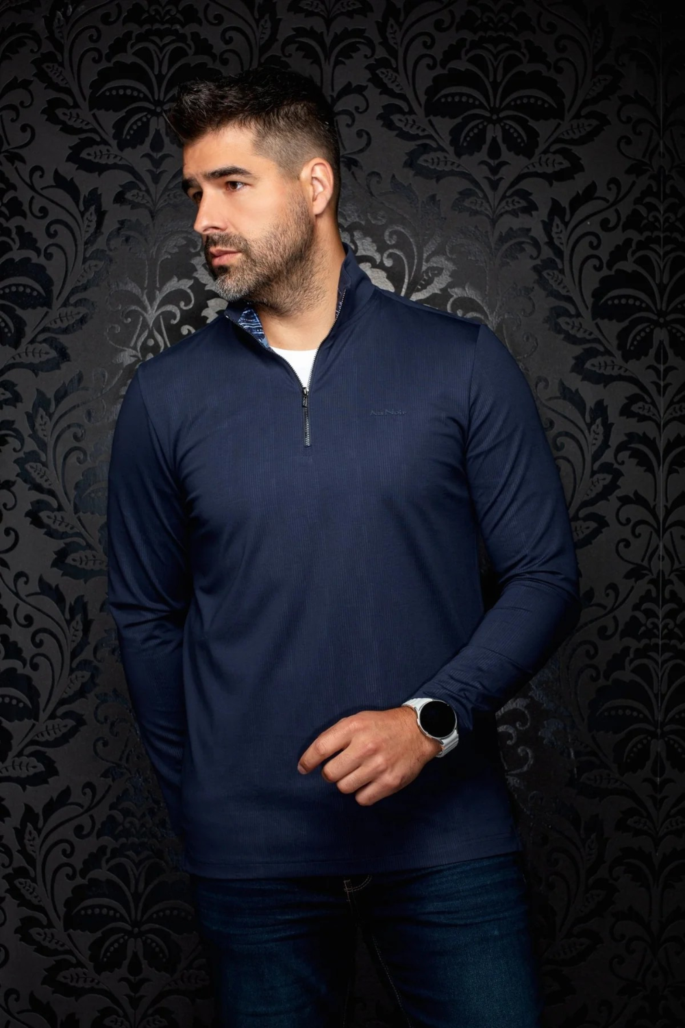 Broderick's Clothing Co. Au Noir BONNEFOI navy blue quarter-zip sport sweater worn by a man against damask wallpaper