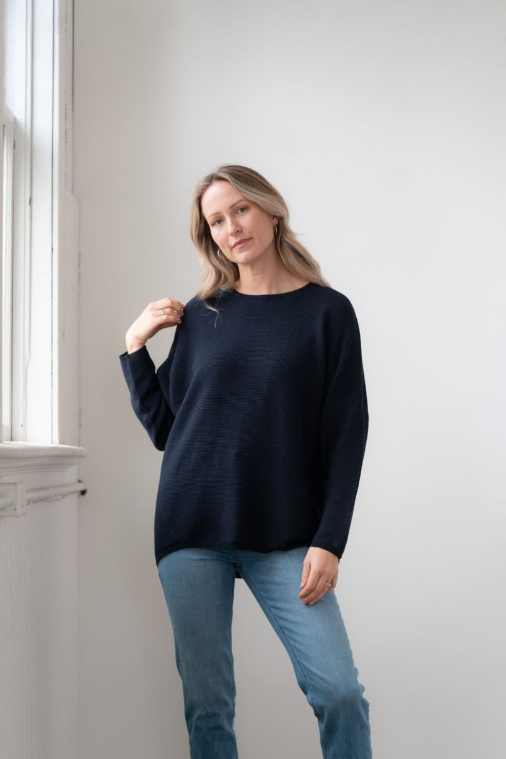 Broderick's Clothing Co. Sara crew neck sweater in navy blue rib knit with dolman sleeves worn by a woman.