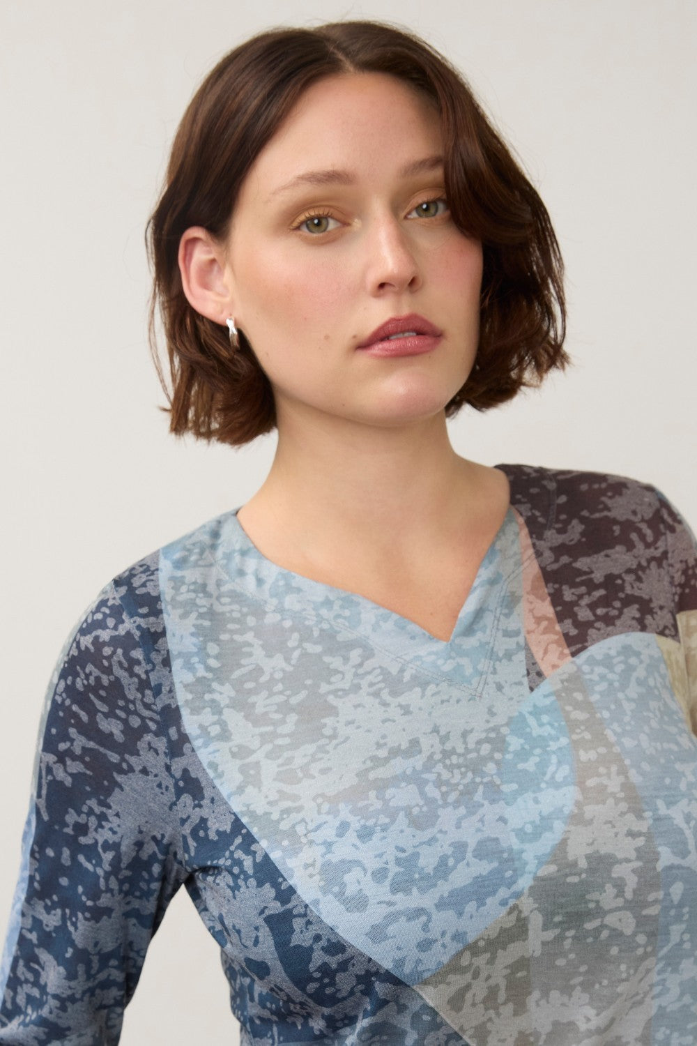 Broderick's Clothing Co. 3/4 sleeve notch neck top in a blue and grey abstract print worn by a woman.