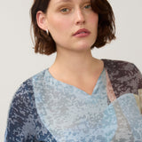 Broderick's Clothing Co. 3/4 sleeve notch neck top in a blue and grey abstract print worn by a woman.