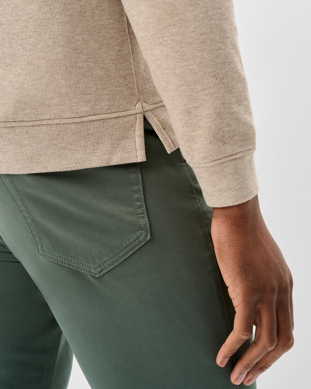 Broderick's Clothing Co. oatmeal heathered cotton-blend hoodie with side hem vents paired with olive green trousers.