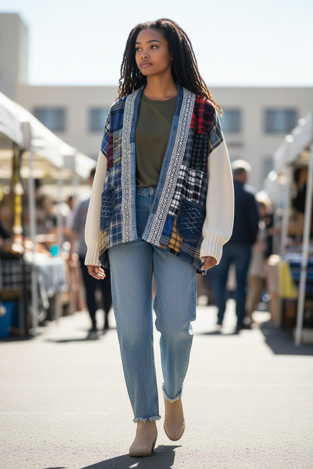 Model wearing a Broderick's Clothing Co. Shannon Addison patchwork cardigan with knit sleeves at an outdoor market.