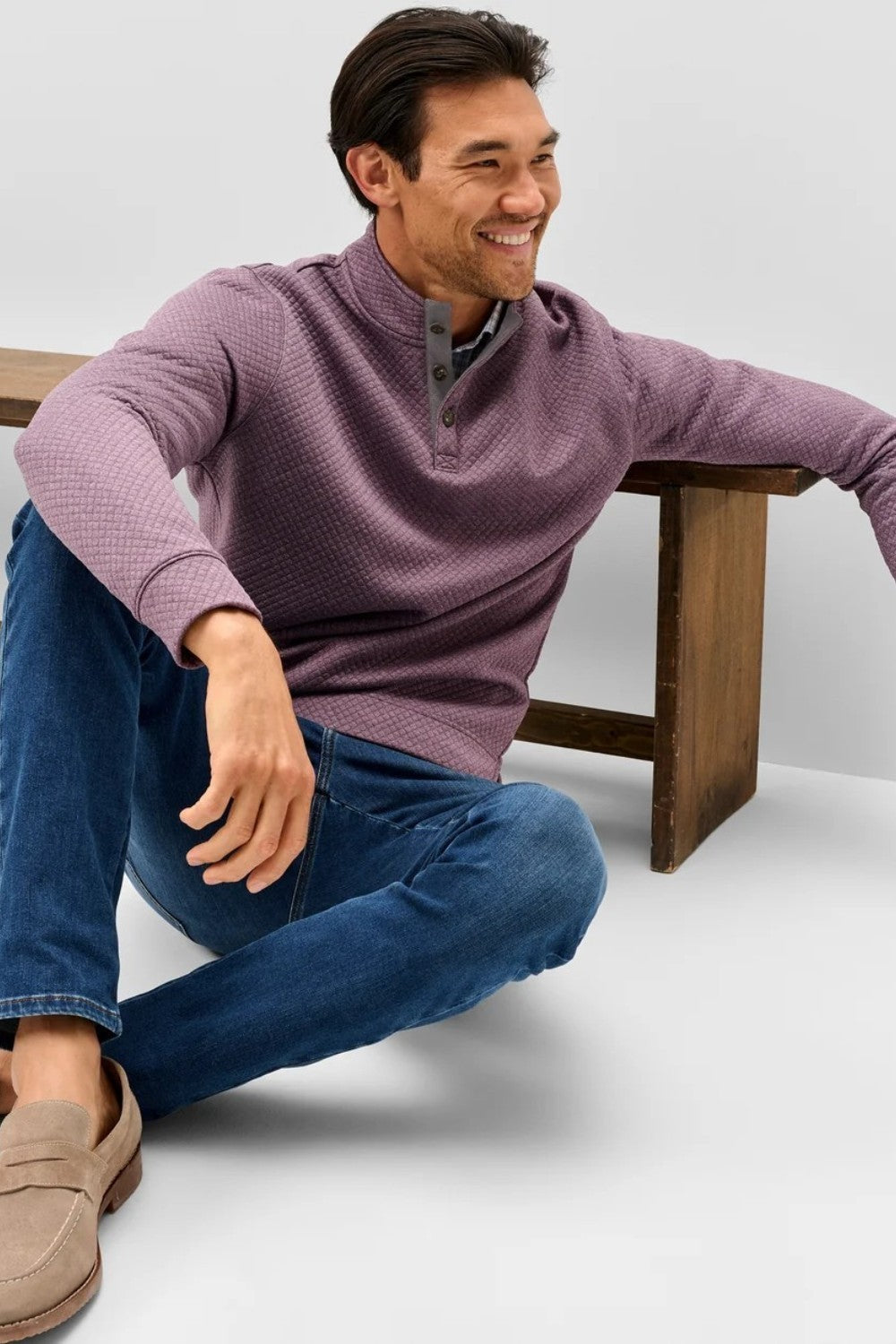Broderick's Clothing Co. purple diamond-knit henley pullover with suede placket details worn by a smiling man.