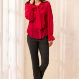 Broderick's Clothing Co. red polka dot crinkle chiffon blouse with bow-tie neck and ruffled cuffs on a smiling model.