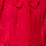 Broderick's Clothing Co. red sheer crinkle chiffon blouse with polka dot texture and a feminine bow-tie neck detail.