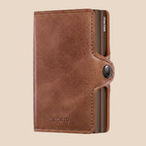 Broderick's Clothing Co. Secrid Twinwallet in vintage cognac-brown leather with a secure snap button closure.