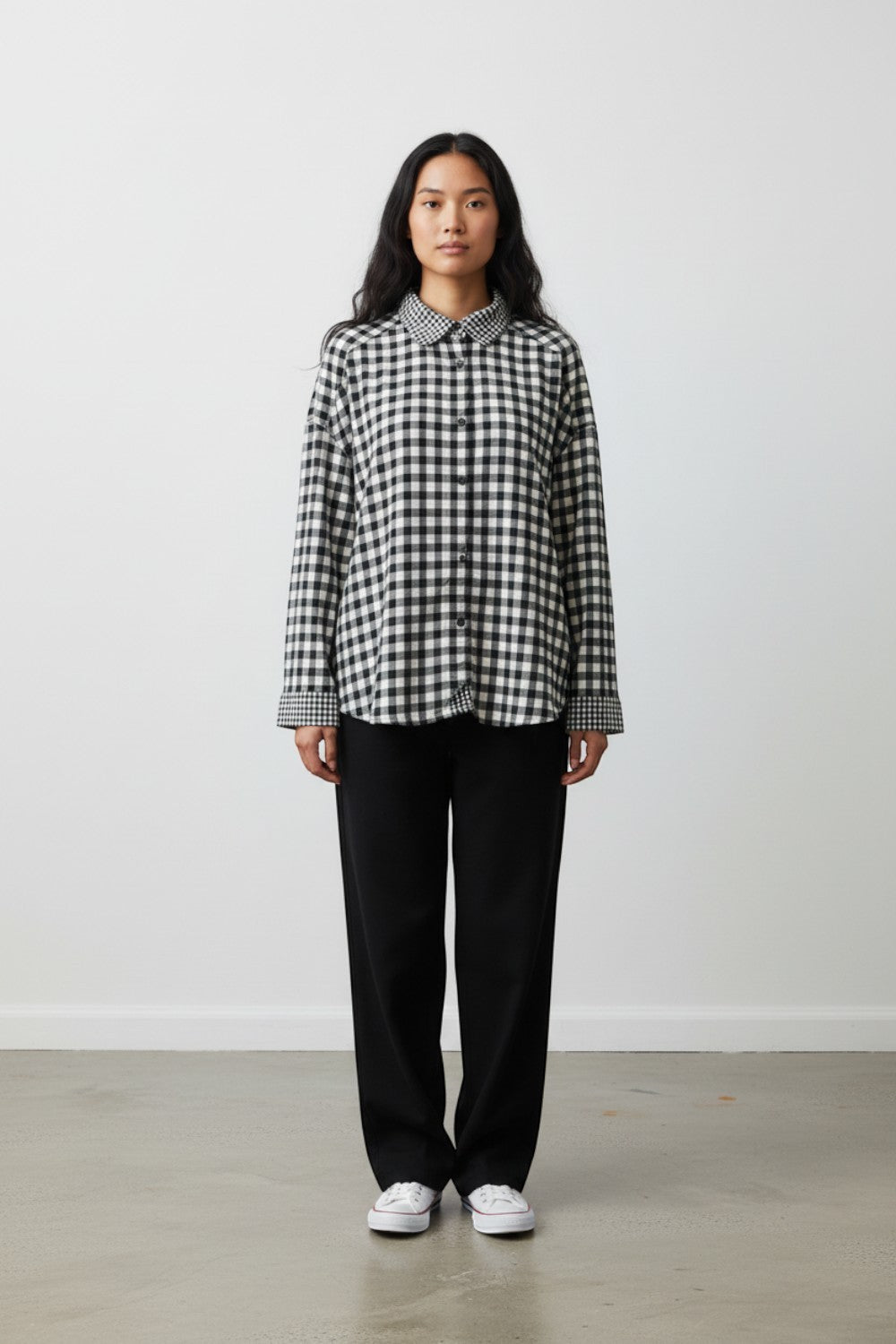Model wearing Broderick's Clothing Co. Shannon Passero Aubrey black and white gingham button-down shirt with trousers.