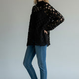 Broderick's Clothing Co. Shannon Passero Tara black open-knit high-neck sweater with circular cutouts on a model