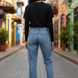 Model wearing Broderick's Clothing Co. Shannon Passero Zoya black long-sleeve top and blue jeans on a city street