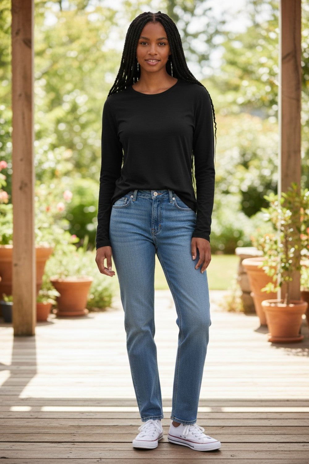Model wearing a black Shannon Passero Zoya long-sleeve top from Broderick's Clothing Co. with blue jeans and sneakers.