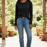 Model wearing a black Shannon Passero Zoya long-sleeve top from Broderick's Clothing Co. with blue jeans and sneakers.