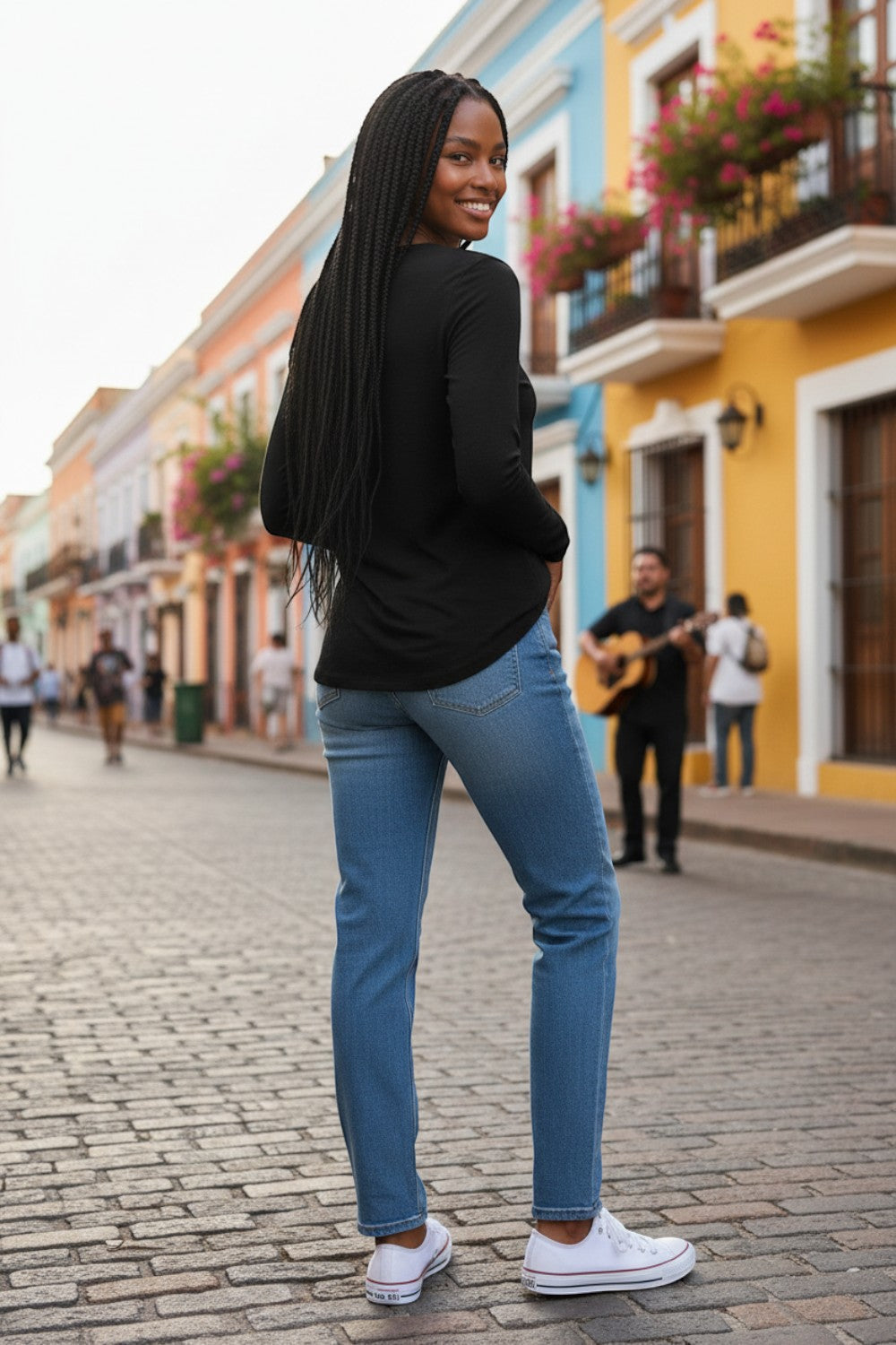 Broderick's Clothing Co. Shannon Passero Zoya black long-sleeve top worn with blue jeans on a vibrant city street