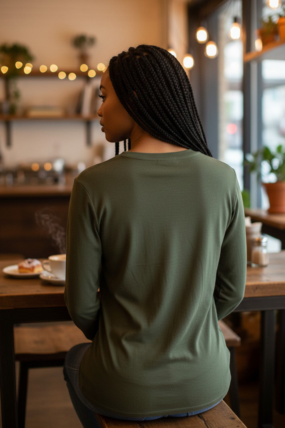 Broderick's Clothing Co. Shannon Passero Zoya olive green long sleeve top worn by a woman in a cafe