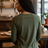 Broderick's Clothing Co. Shannon Passero Zoya olive green long sleeve top worn by a woman in a cafe