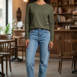 Broderick's Clothing Co. Shannon Passero Zoya olive green long sleeve top worn with blue jeans in a cafe setting