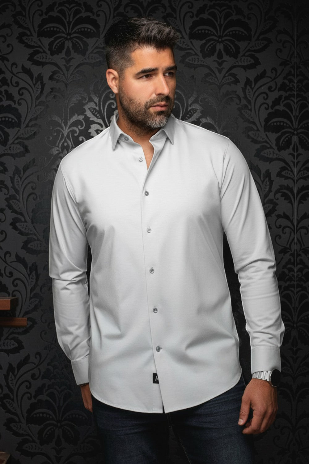 Broderick's Clothing Co. Au Noir Alexander silver long sleeve knit dress shirt worn by a man against a damask wall