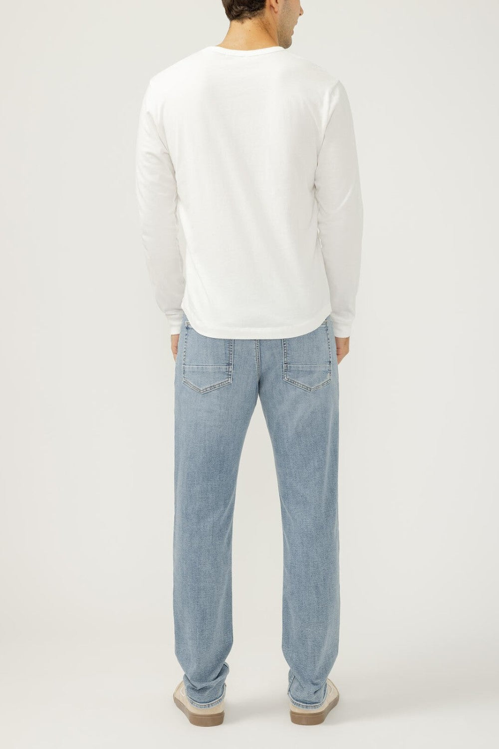Broderick's Clothing Co. Silver Jeans Co. Machray slim straight light wash denim jeans worn by a man from behind.
