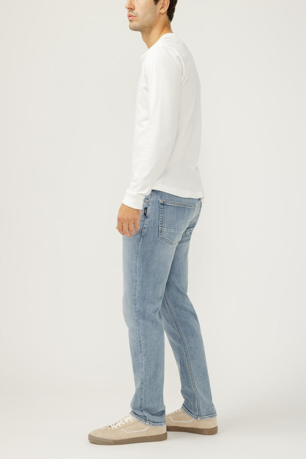 Broderick's Clothing Co. Silver Jeans Co. Machray slim straight light wash denim jeans worn by a man in profile