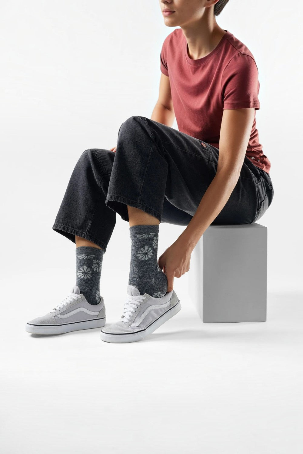 Broderick's Clothing Co. Smartwool floral crew socks in grey worn by a model with casual sneakers and black jeans.