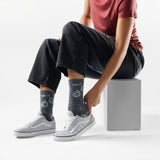 Broderick's Clothing Co. Smartwool floral crew socks in grey worn by a model with casual sneakers and black jeans.