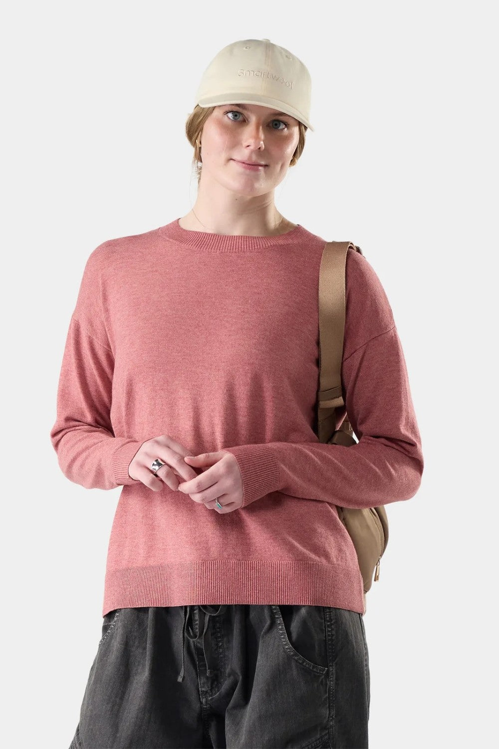 Broderick's Clothing Co. Smartwool Edgewood crew sweater in dusty rose worn by a woman with a beige cap and backpack.