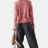 Broderick's Clothing Co. Smartwool Edgewood crew sweater in dusty rose worn by a woman with a cap and dark trousers