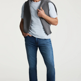 Broderick's Clothing Co. 34 Heritage medium blue tapered leg jeans with contrast stitching on a male model
