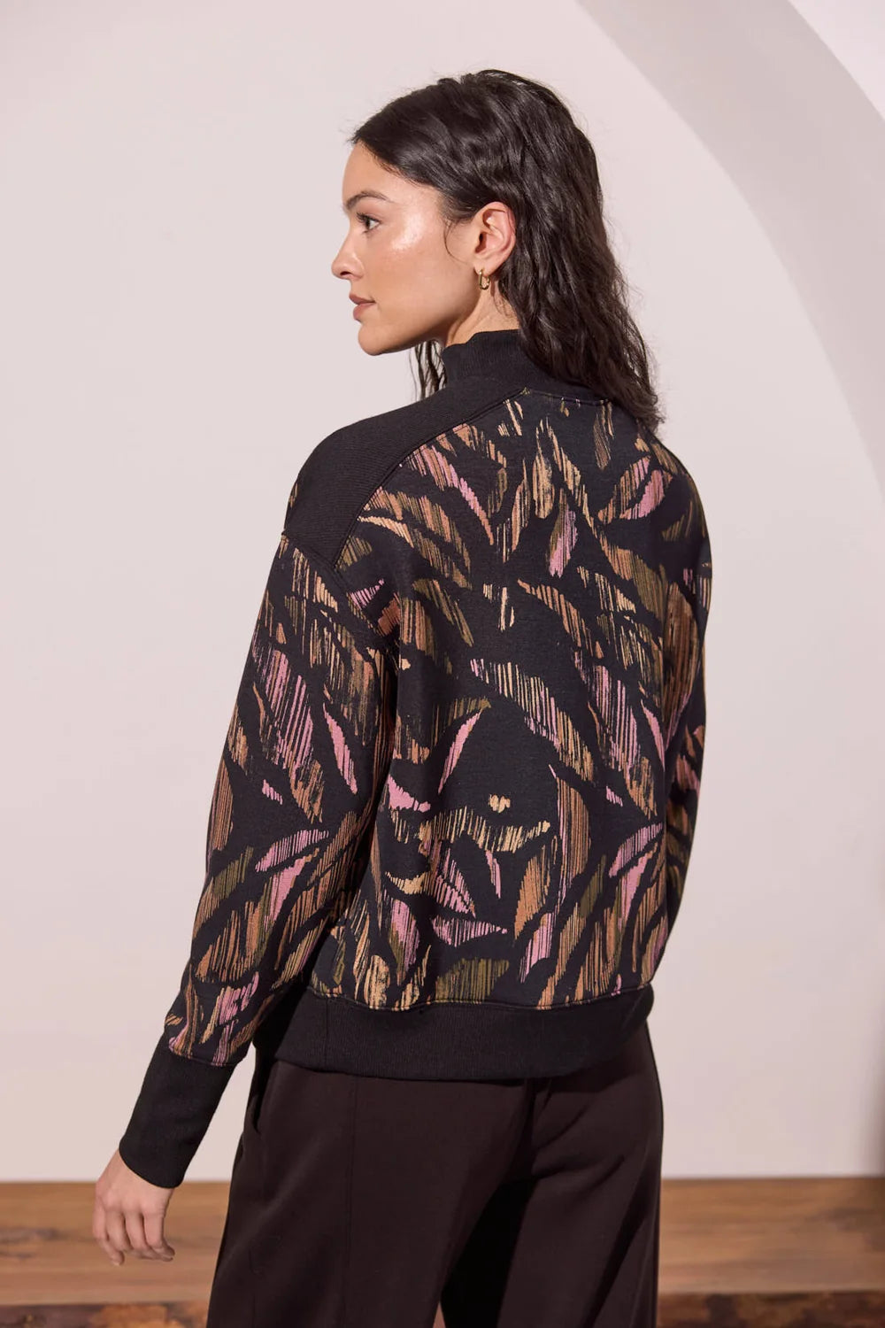 Broderick's Clothing Co. tribal print modal mock neck top with black ribbed trim and long sleeves, back view.
