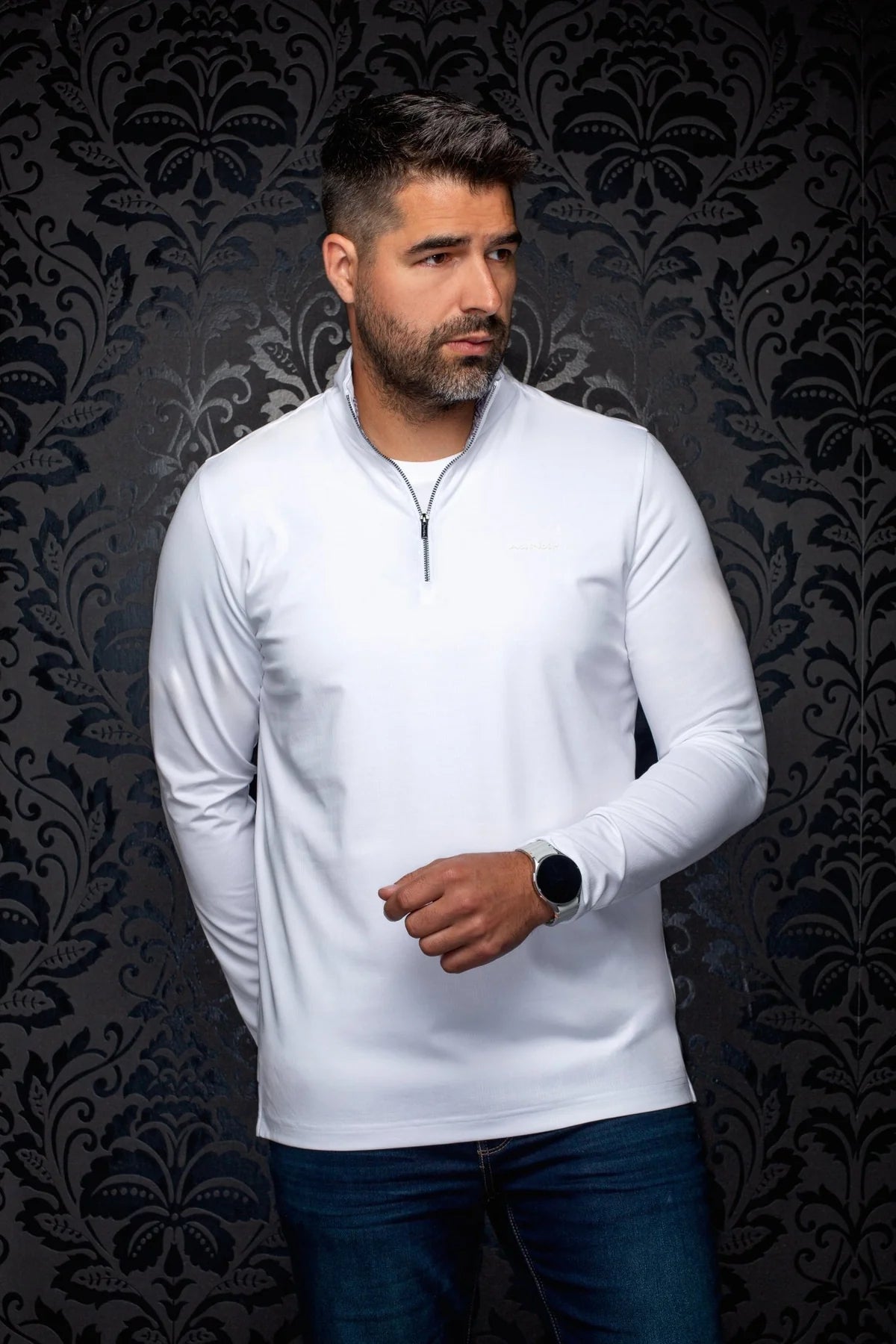 Broderick's Clothing Co. Au Noir white mock neck quarter-zip knit pullover worn by a man against a damask background